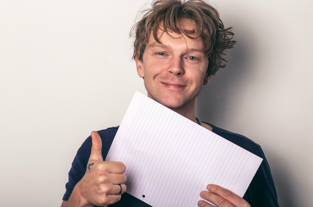 Mężczyzna z kartką i wyciągniętym kciukiem